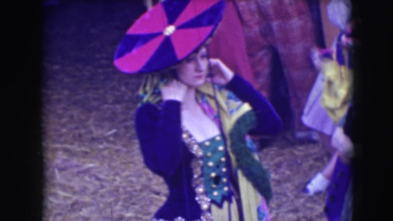 A woman in a theatrical costume adjusts a large red and blue geometric hat in the 1948 Sarasota circus setting.