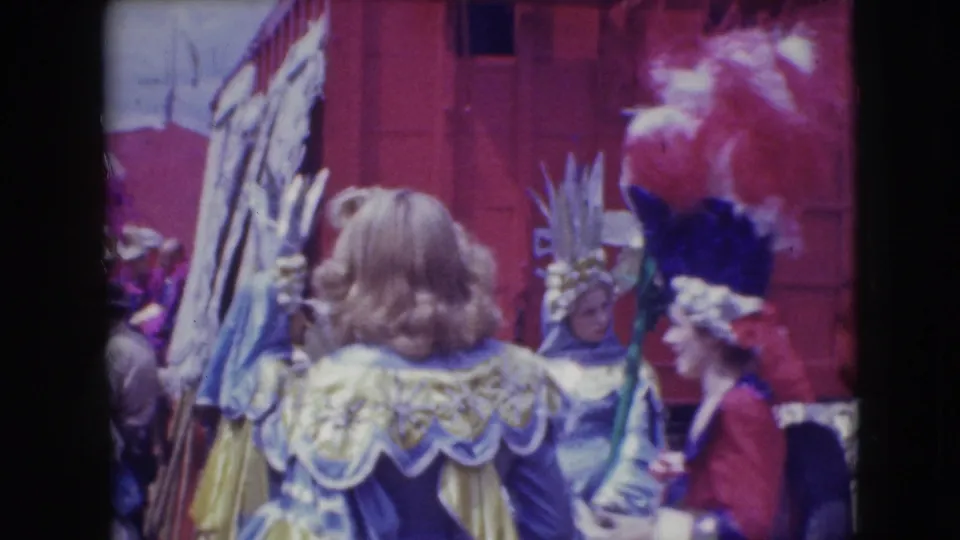 Costumed adults at the 1948 Sarasota Ringling Brothers gathering, including feathered headpieces, ruffled garments and a red backdrop.