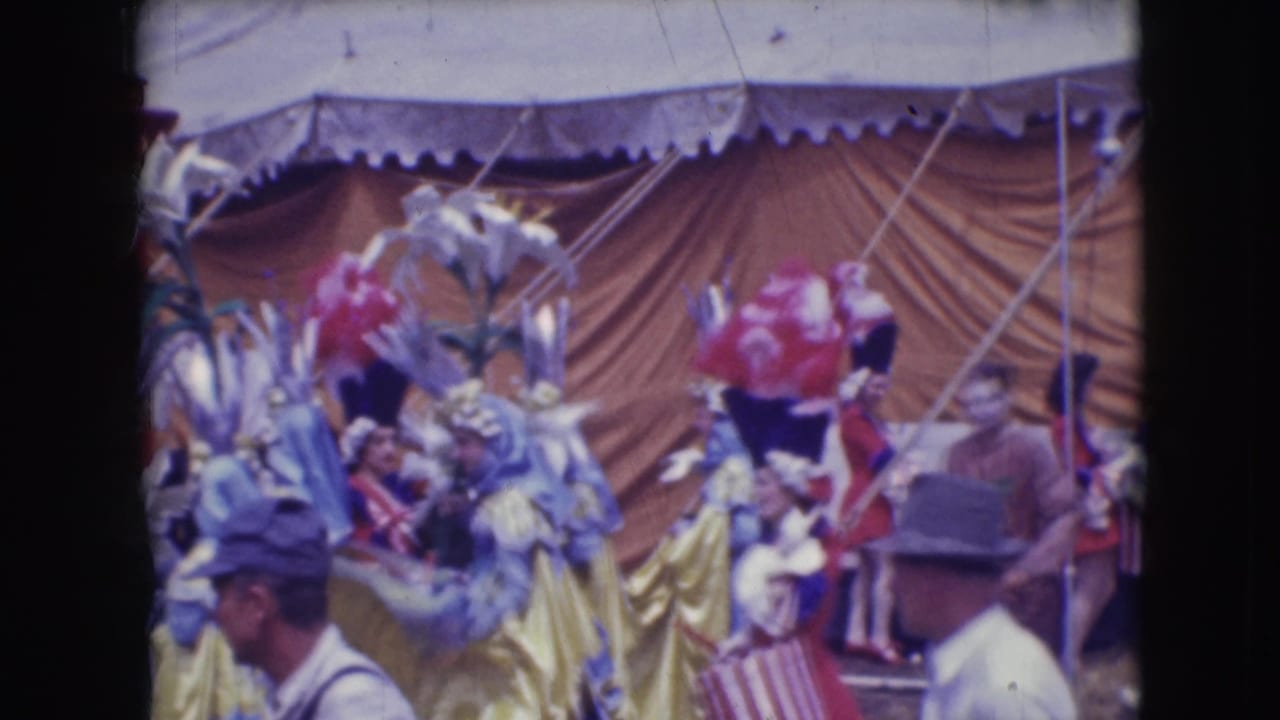 1948 Sarasota circus footage showing feathered performers under canvas as spectators pass close to the camera.