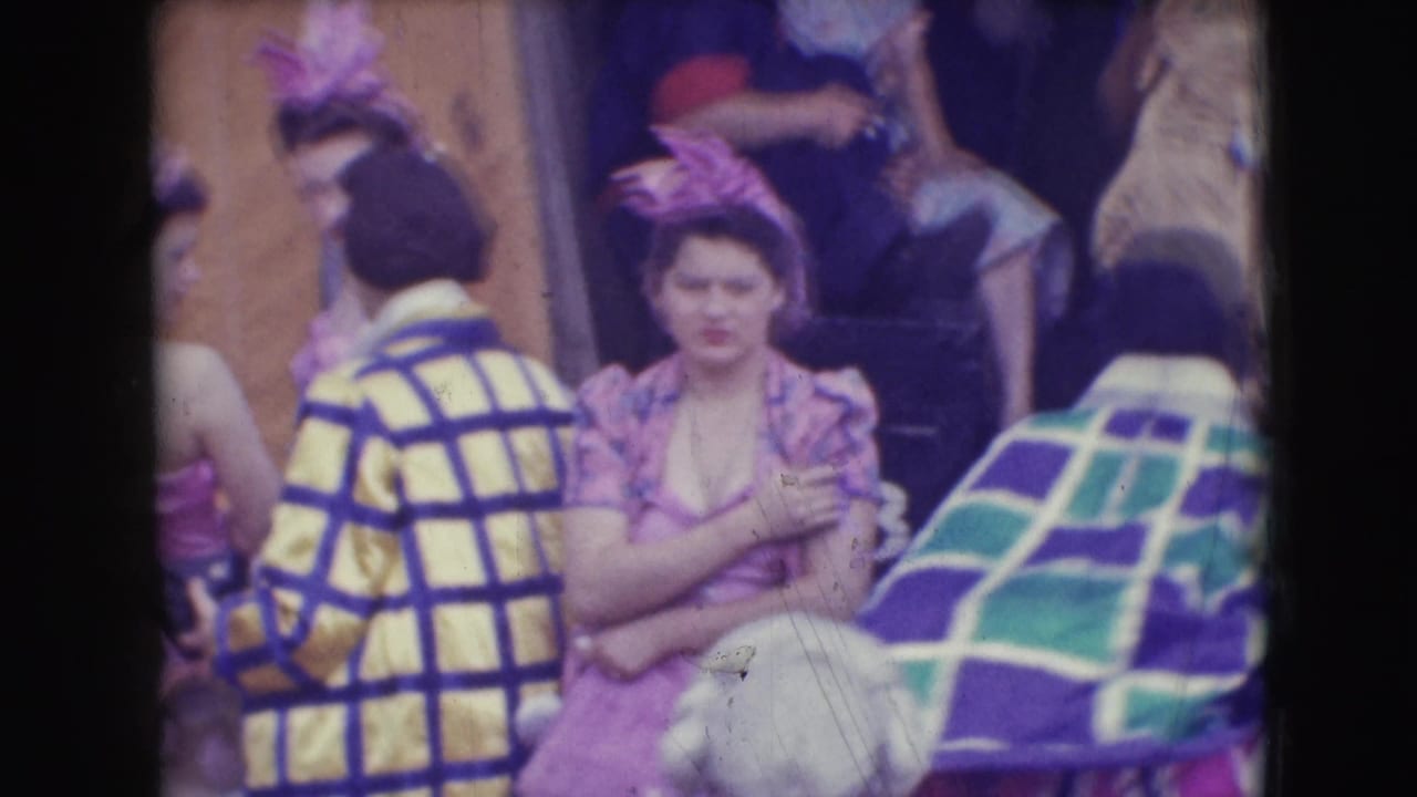 Costumed adults at the Ringling Brothers Sarasota setting gather in patterned coats, pink outfits, and feathered headpieces.