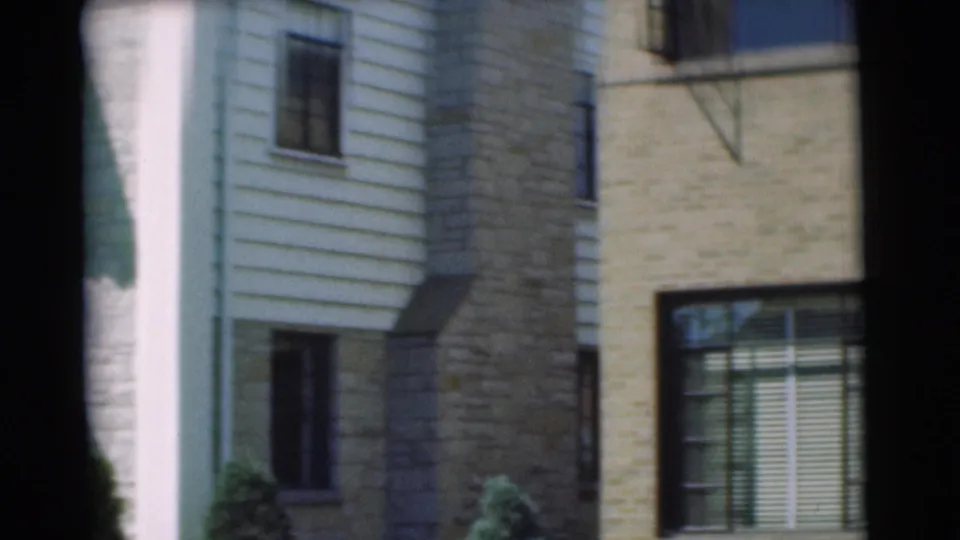 The final frame shows a closer section of the residential exterior, including windows, siding, masonry surfaces, blinds, and part of a fire escape.