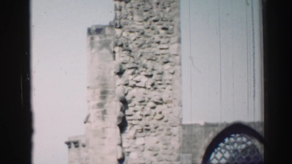 1952 Edinburgh frame showing a cropped chapel ruin with rough masonry, pale sky, and the lower part of an arched window.
