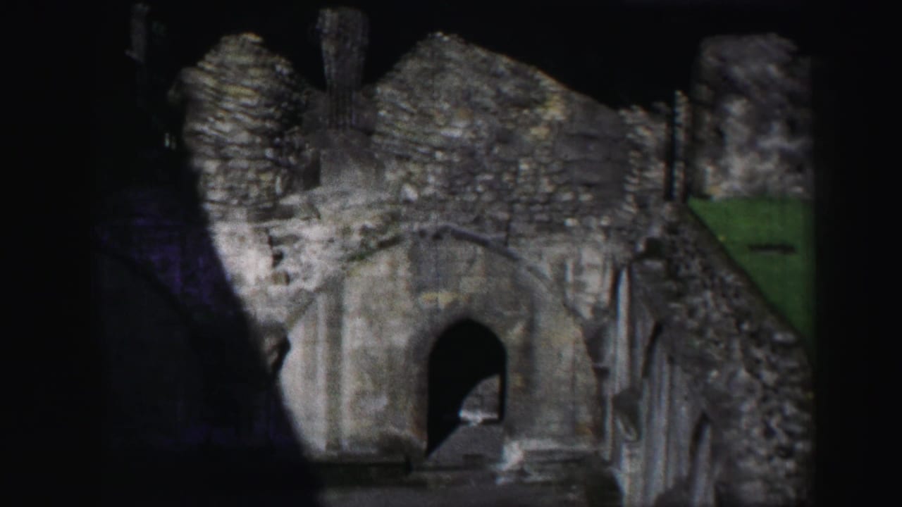 1952 8mm Edinburgh footage showing weathered stone ruins, an arched passage, and rough masonry under uneven light.