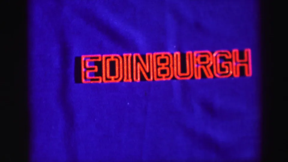 A red outlined sign reading Edinburgh appears against a blue cloth-like background in the 1952 Scotland clip.
