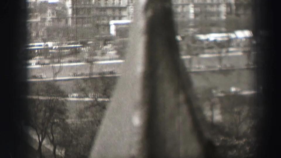 1952 Edinburgh frame from an elevated vantage, showing a street and pavement below with buildings beyond and the view largely softened by foreground blur.