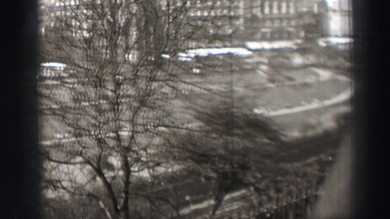 Elevated 1952 Edinburgh street view with bare trees in front and period buildings beyond.