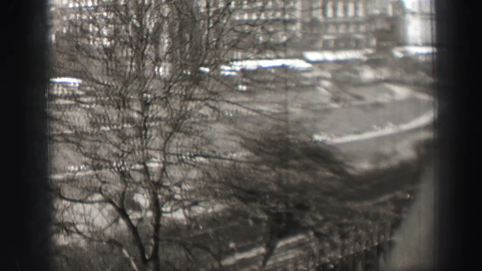 Elevated 1952 Edinburgh street view with bare trees in front and period buildings beyond.