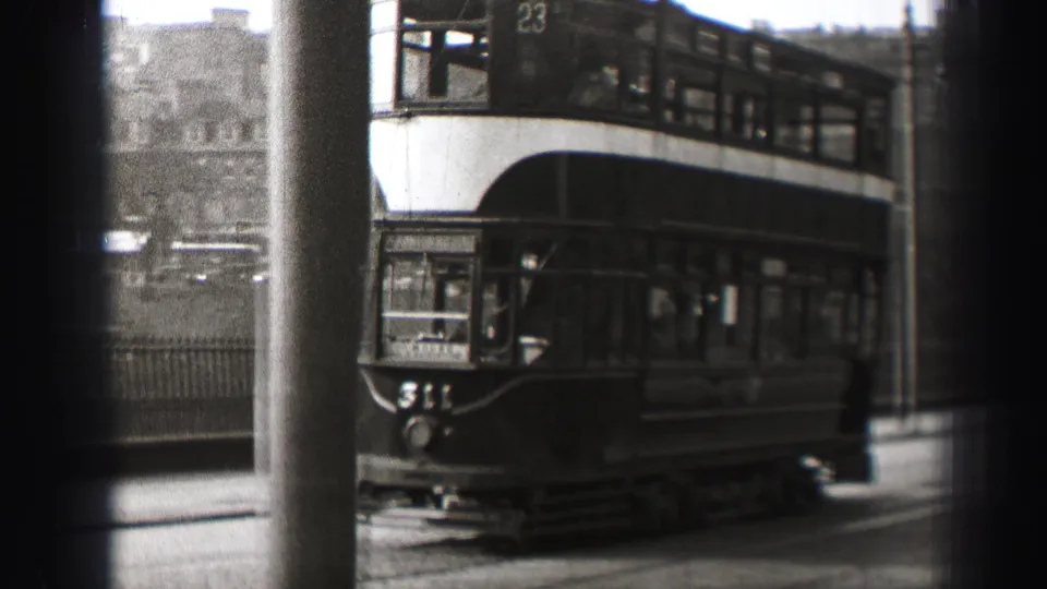 Double-decker tram moving through an Edinburgh street in black-and-white 8mm footage from 1952.