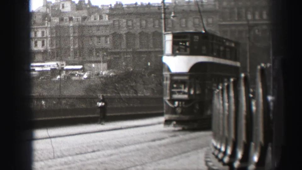 Rear view of a double-decker tram departing along an Edinburgh street in 1952 home-movie footage.