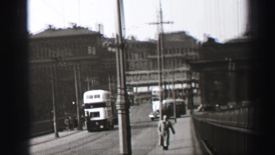 Edinburgh street view in black and white, with a route 9 bus in the distance, pedestrians, cars, railings, and overhead street wires.