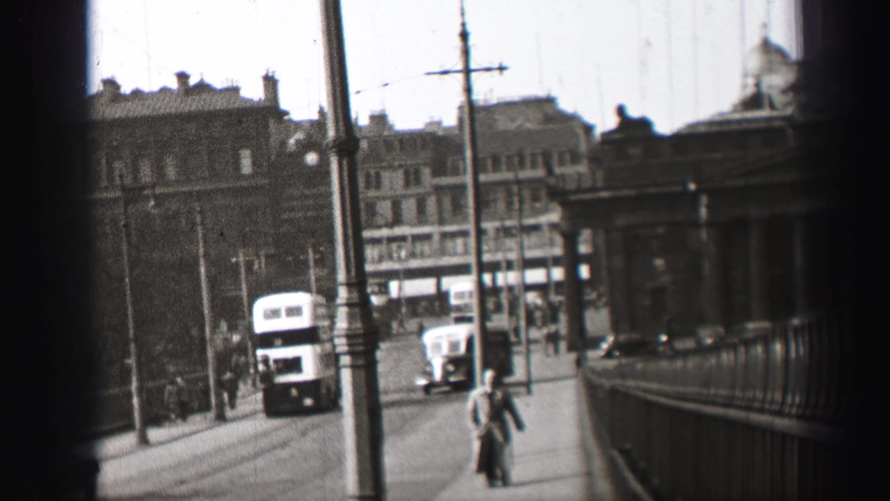 1952 Edinburgh street view with a double-decker bus, classic car, pedestrians, railings, poles and overhead wires.