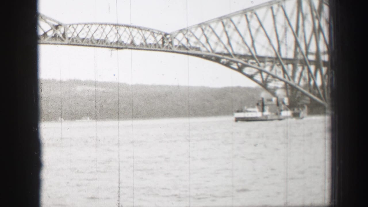 Steel truss bridge over water with a small vessel beneath the span.