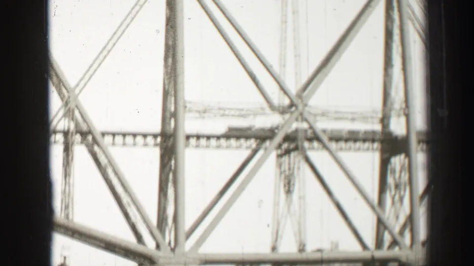 Close 1952 8mm view of bridge piers, diagonal bracing, and a lower deck or span over water in Scotland.