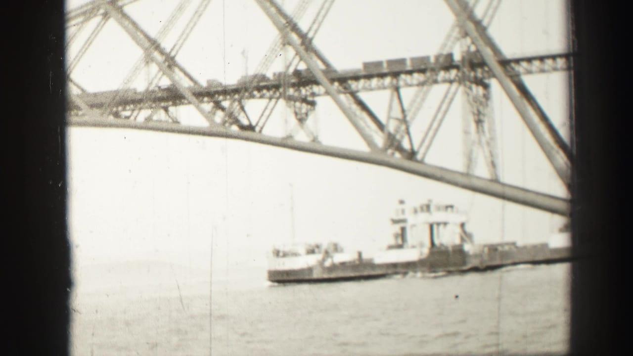 1952 8mm home-movie view near Edinburgh showing a steel truss bridge and a ship on the water, framed by dark window bars.