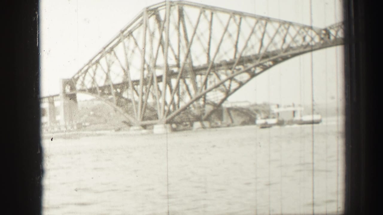 1952 8mm view of the Forth Bridge in Scotland spanning water, with steel trusswork and river surface in the foreground.