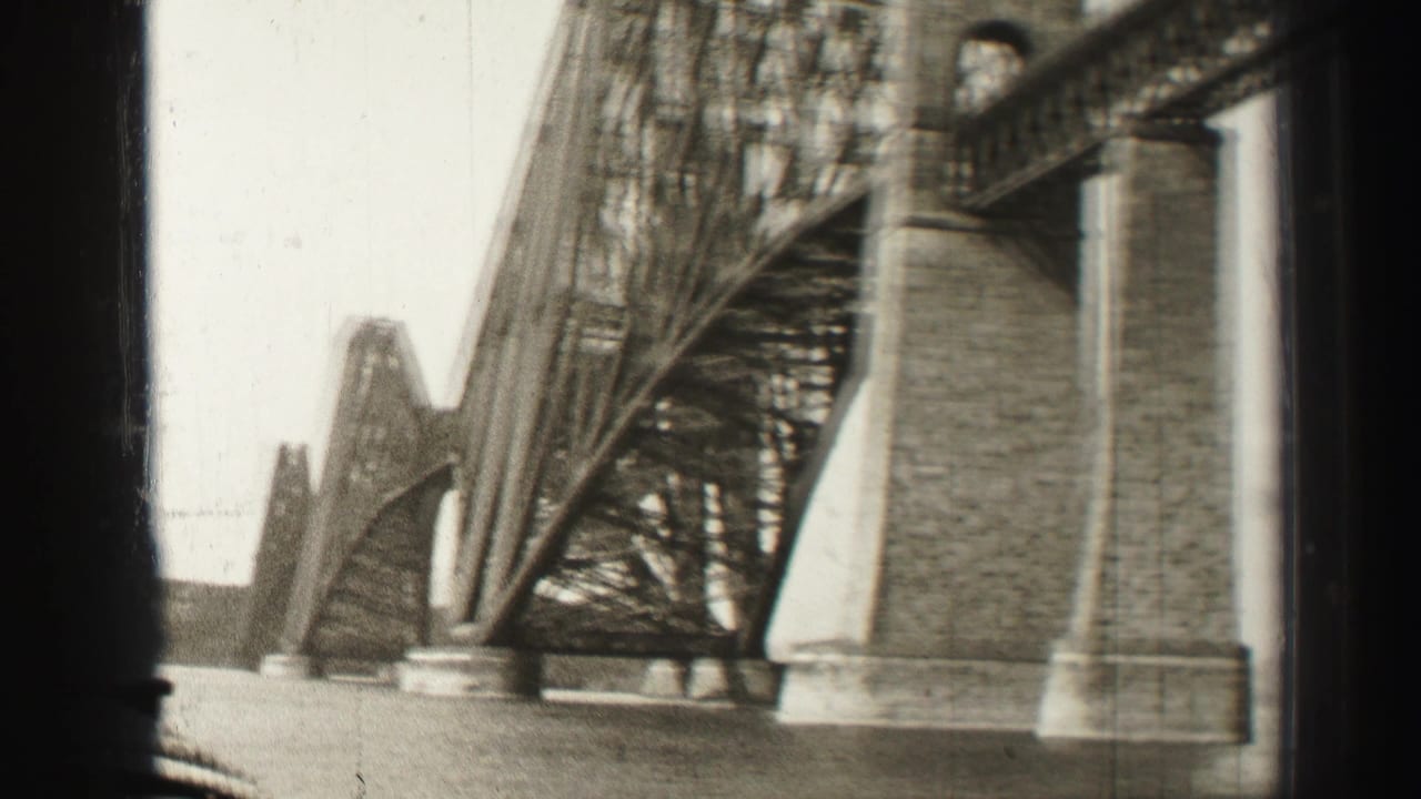 Close view of steel bridge latticework and a large masonry pier beside the water.