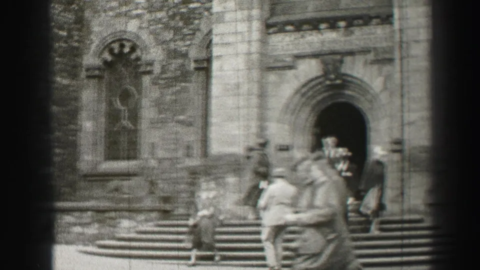 1952 Scotland exterior view of people in formal clothing near an arched cathedral doorway and broad steps.