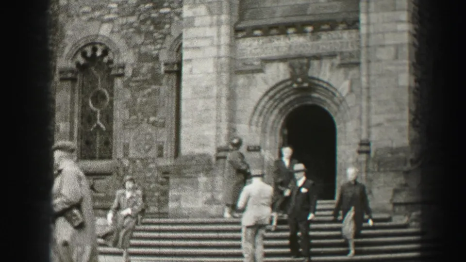 1952 Scotland frame with formal-dressed visitors and passersby on the steps of a stone cathedral entrance.