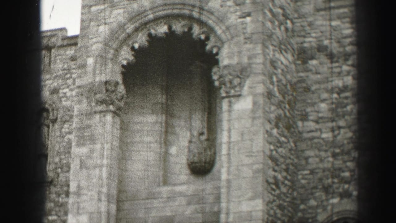 Stone wall with a recessed arched opening and narrow vertical architectural detail.