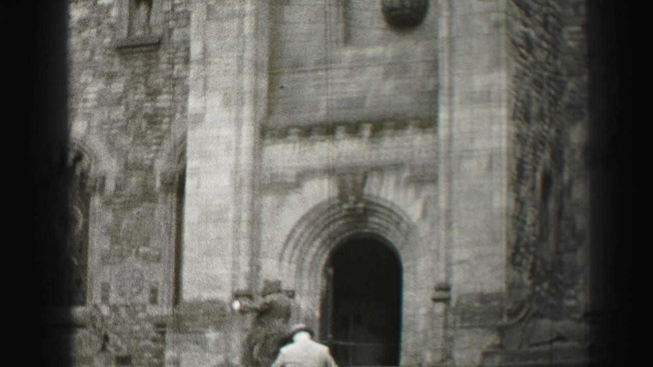 A suited man walks toward a dark arched church doorway on stone steps.