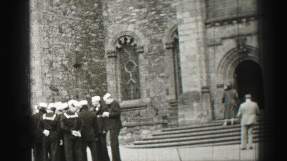 Sailors in white caps and dark uniforms stand near the steps of a stone church in Scotland, 1952 metadata supported.