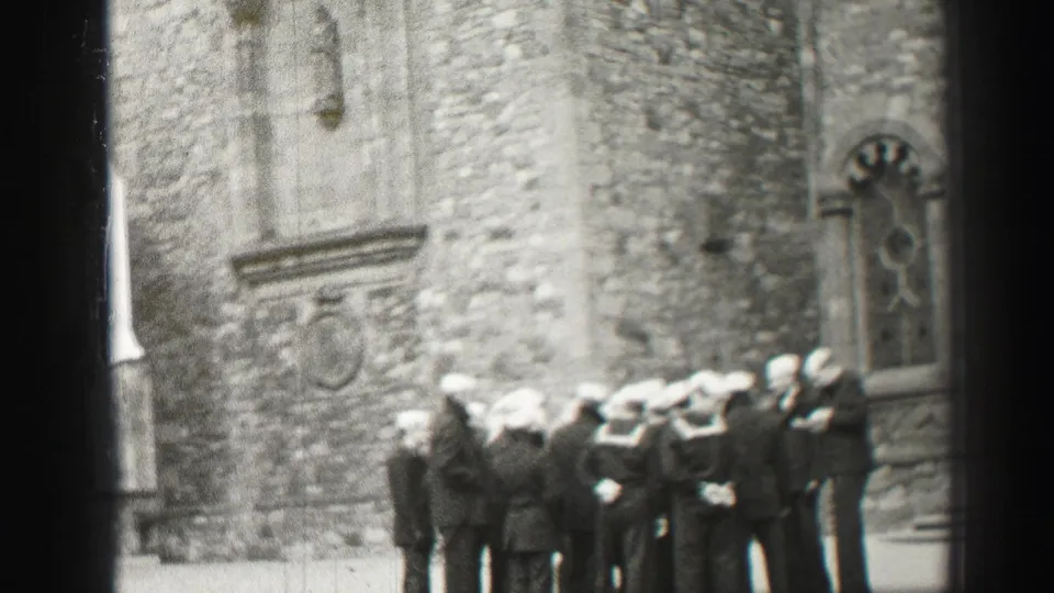A group of sailors stands outside a historic stone church, with the 1952 Scotland setting supported by clip metadata.