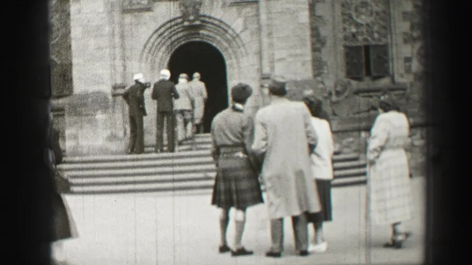 1952 Edinburgh church exterior with kilted men, visitors in coats, and people entering an arched doorway.