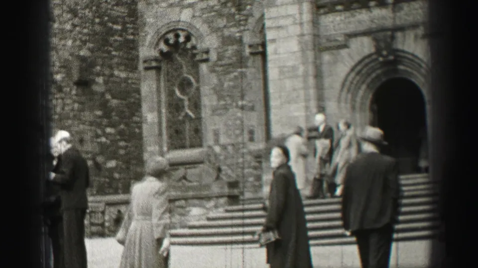 Mid-century Edinburgh church exterior with visitors on the steps, a stone window, and figures in coats and hats.