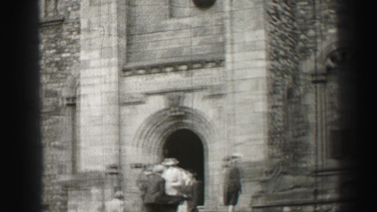 Several adults gather near a dark arched doorway on a stone facade.