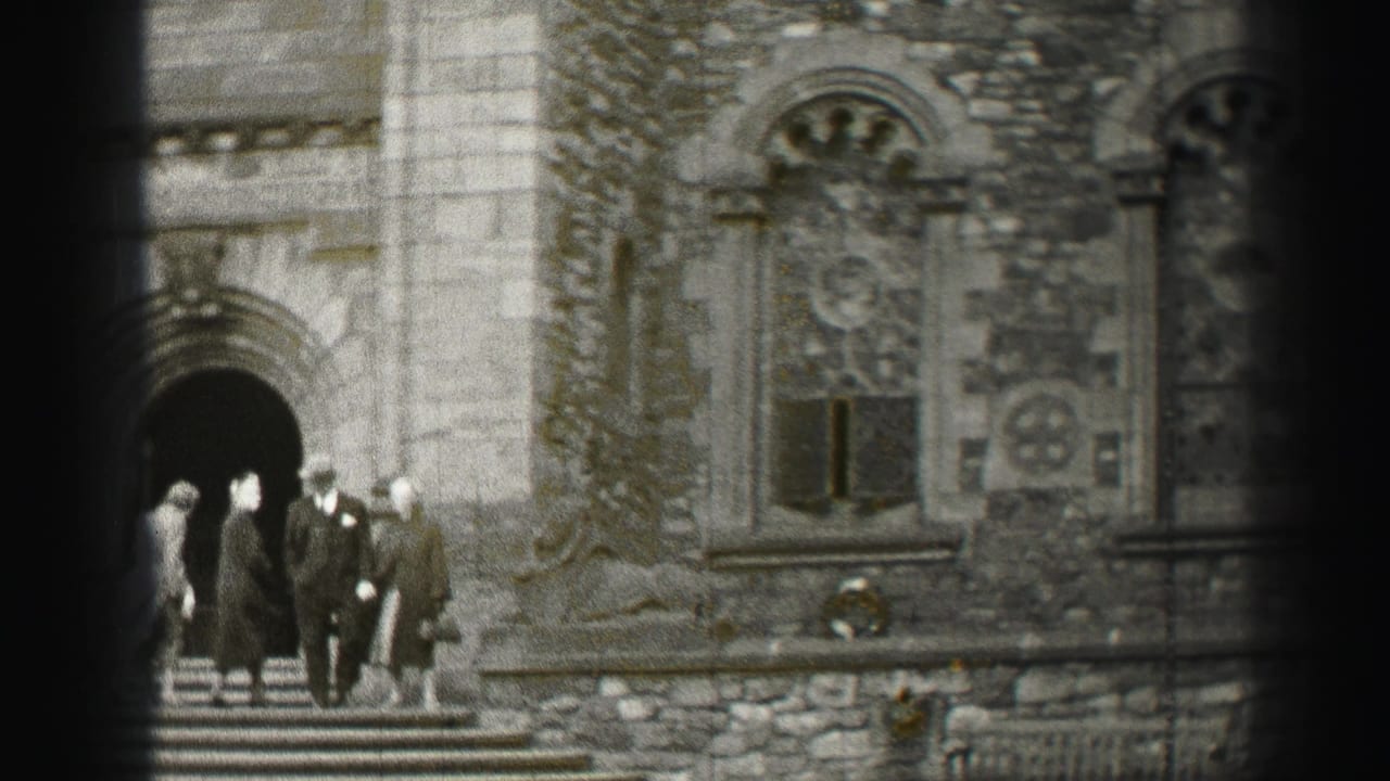 1952 Scotland home-movie frame showing visitors in coats leaving a medieval-style stone doorway.