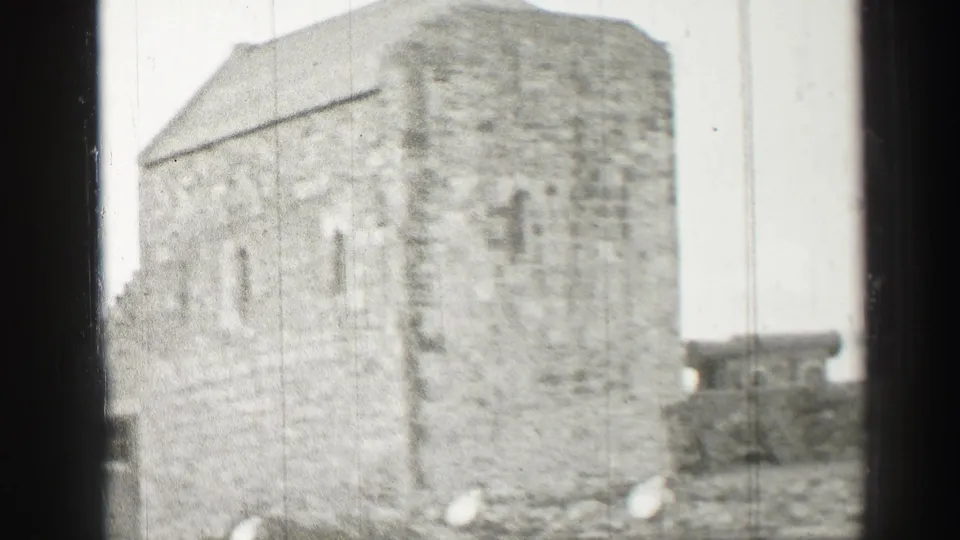 The visitor-shot footage lingers on a rough stone exterior and adjacent low walls in Scotland.