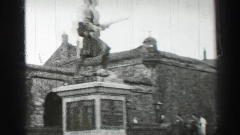 1952 Edinburgh view of a military-style statue on a monument base, with pedestrians and stone architecture nearby.