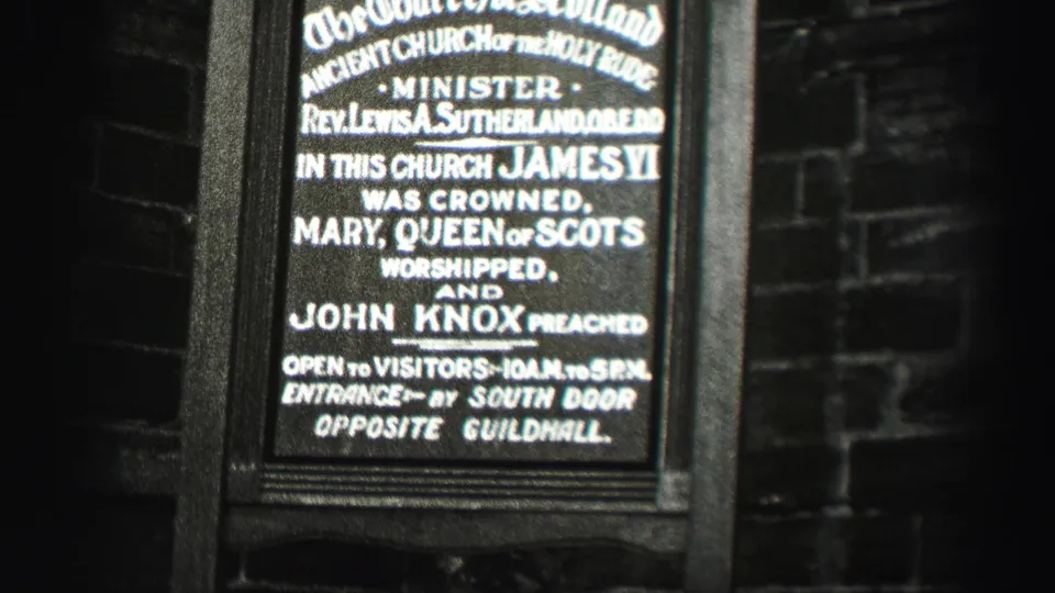 End frame from 1952 Scotland footage showing the church sign with more surrounding dark masonry visible.