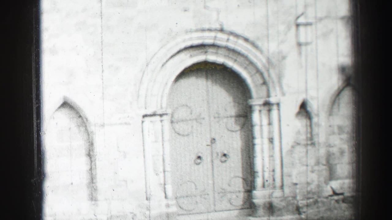 Stone church facade with arched double doors and flanking carved columns.