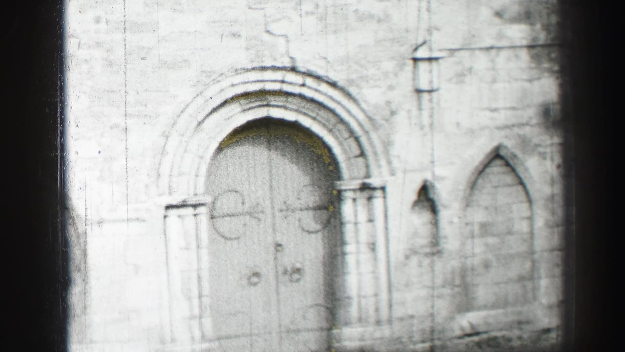 Black-and-white 8mm view of an Edinburgh church facade, centered on the arched doors and surrounding stonework.