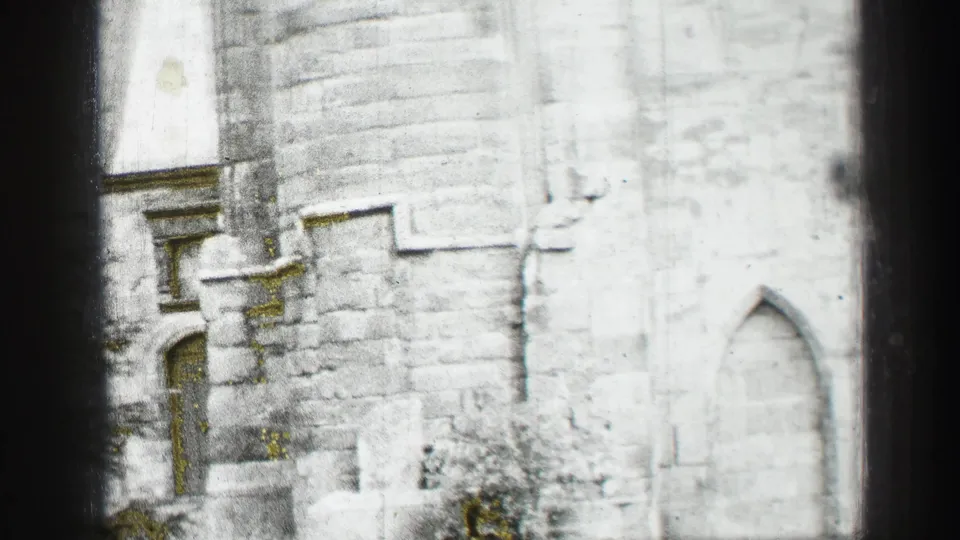 Wider 1952 Edinburgh frame showing part of the church facade, arched doors, masonry courses, and lower stone details.