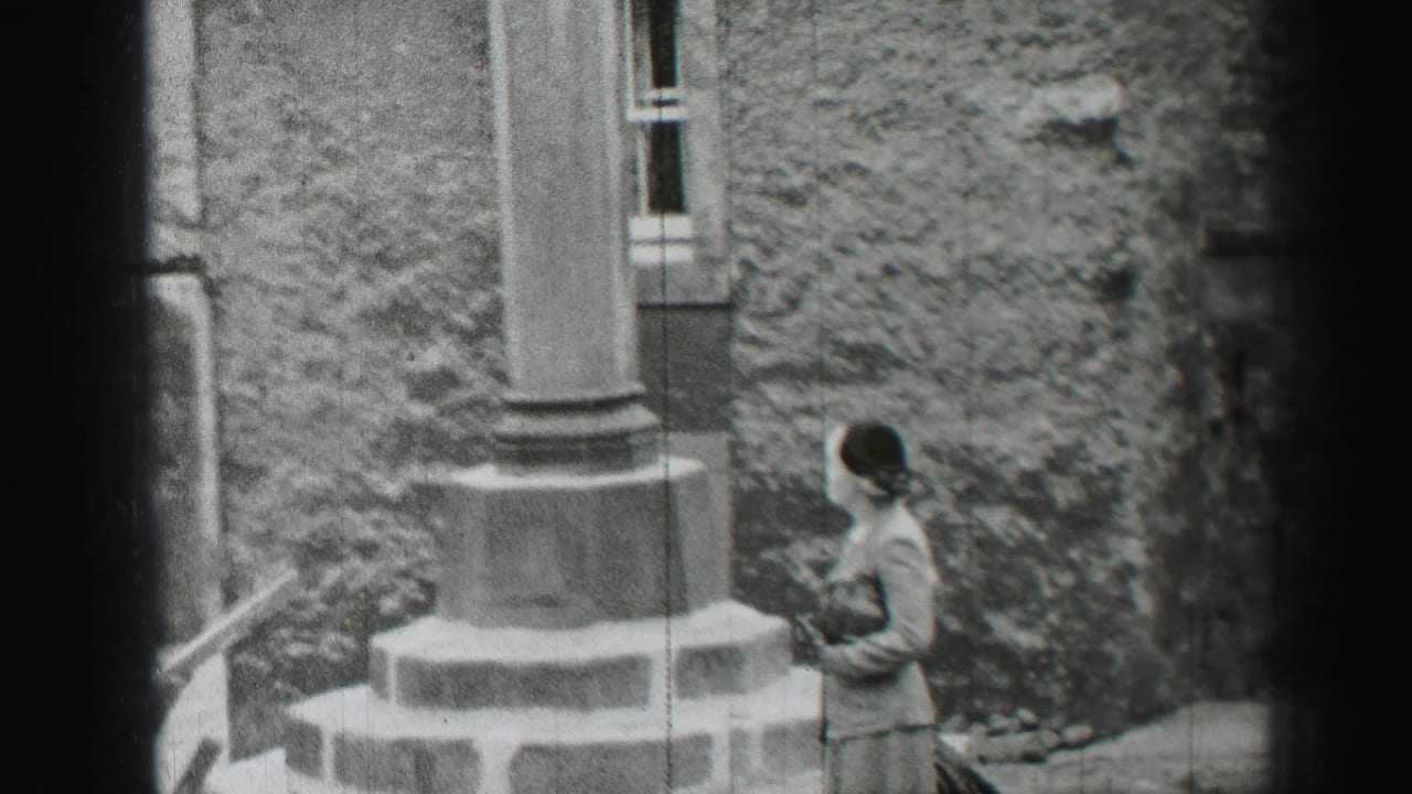 A visitor stands beside rough stonework and a projecting column in an Edinburgh castle setting, from 1952 8mm footage.