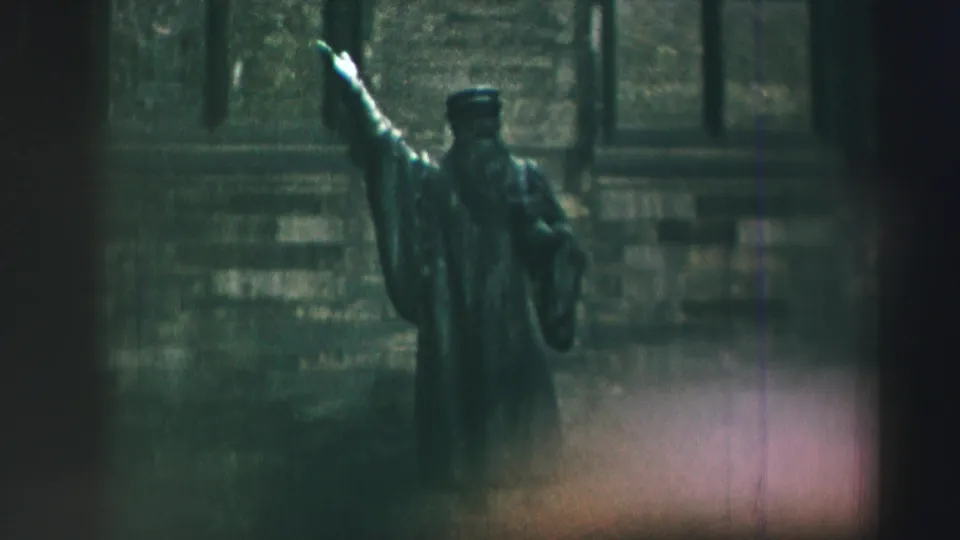 A clearer 1952 Edinburgh frame shows a statue with one arm raised before a stone building on the castle grounds.