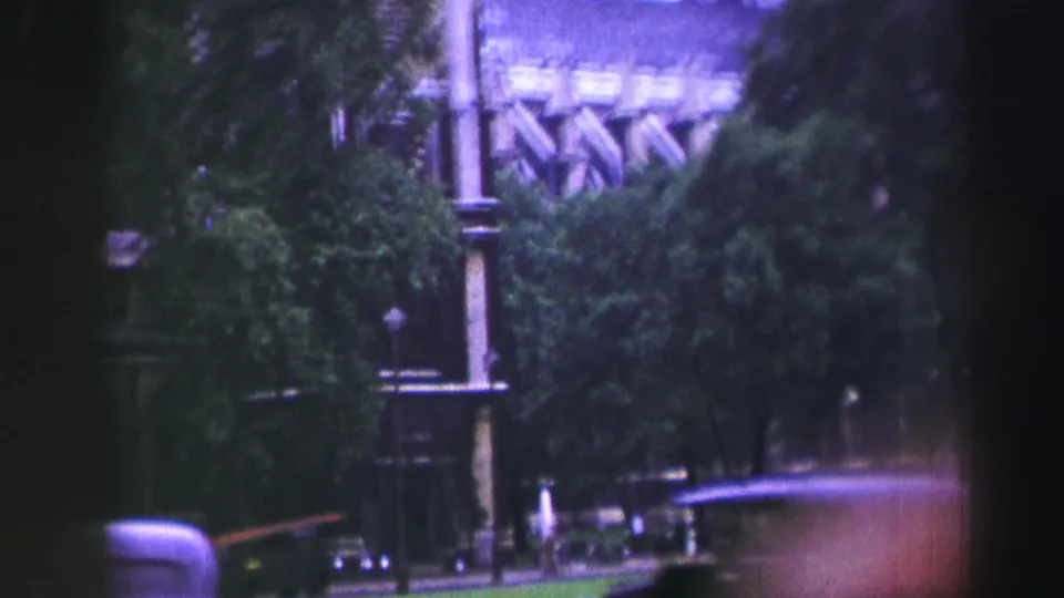Soft 1952 Edinburgh street fragment showing trees, a lamppost, distant architecture, and partial vintage traffic.