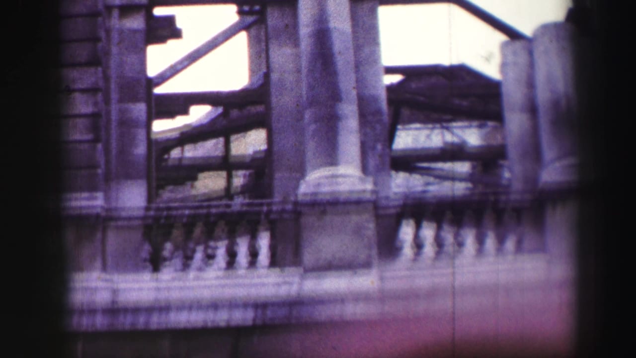 1952 Edinburgh travel frame showing gray stone columns, a balustrade, and shadowed arched openings on a historic facade.