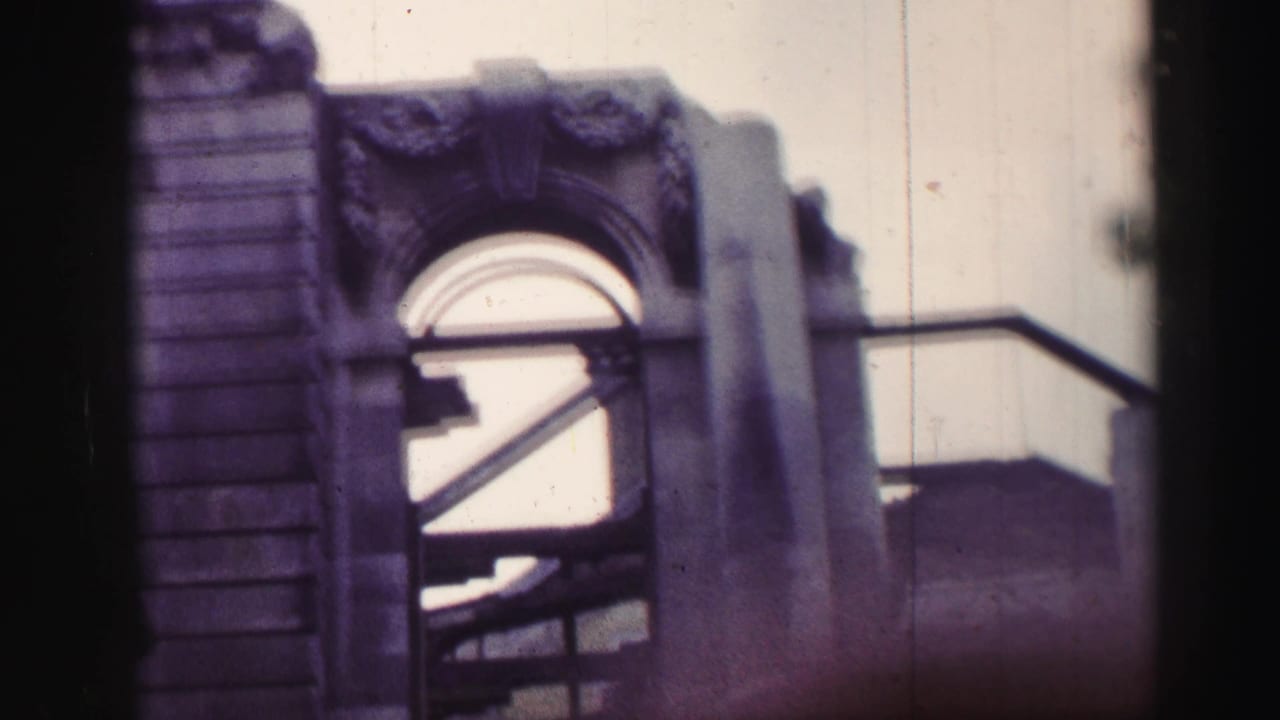 Close view of a stone arch, vertical masonry, railings, and shadowed interior beams.