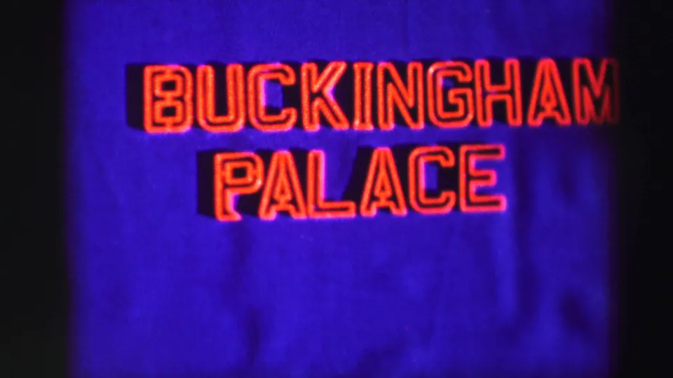The sequence ends on a close view of the Buckingham Palace wording, with red glowing letters and visible 8mm grain and color shift.