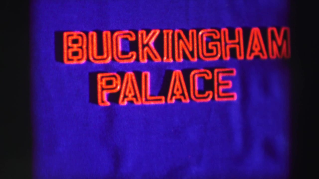 Second view of the red Buckingham Palace title lettering on a blue background, with soft 8mm color and grain.
