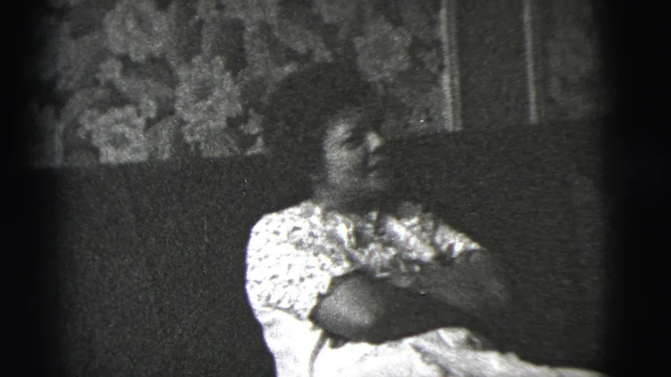 The final frame shows the seated woman looking right, with the sofa, patterned blouse, and floral wall covering still visible.