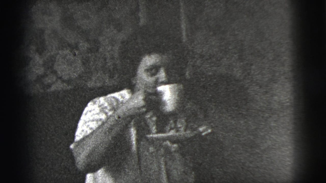 Woman raises a cup near her mouth while holding a saucer indoors.