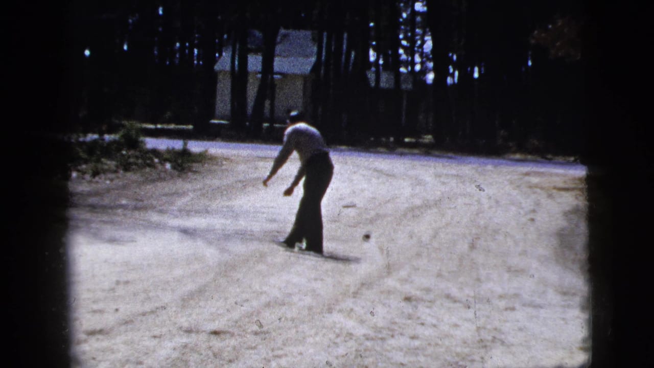 Man stands on the dirt road after dropping a small ball nearby.