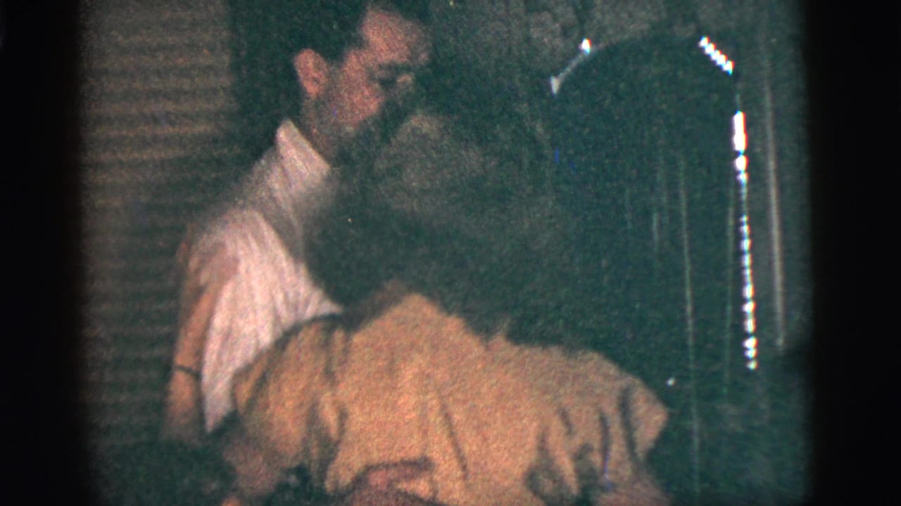 The couple continues dancing in the dim 1956 New York City interior as the woman in a yellow dress bends forward during a turn.