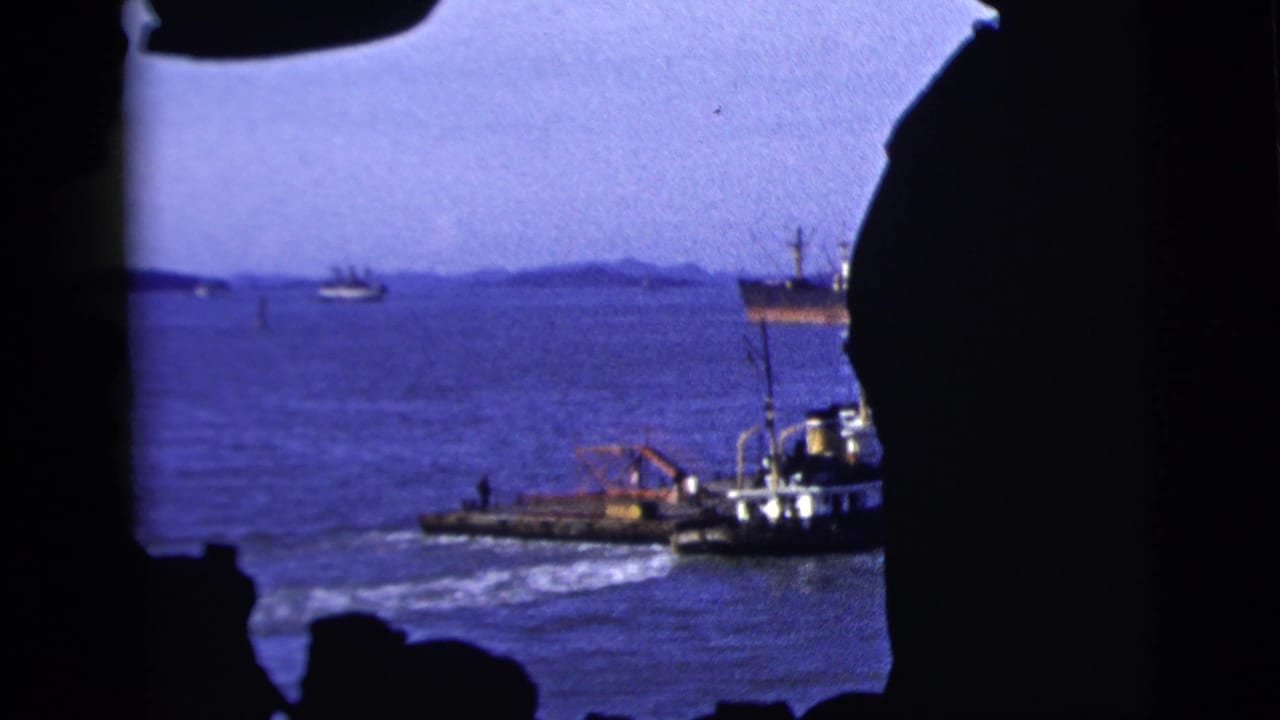 Harbor water and boats seen through a dark irregular opening.