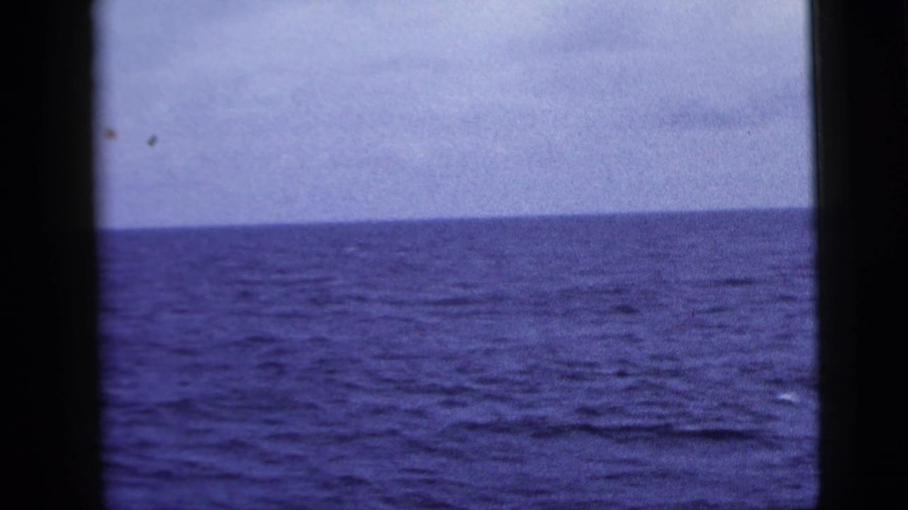 Open blue water and horizon divided by dark vertical frame edges.