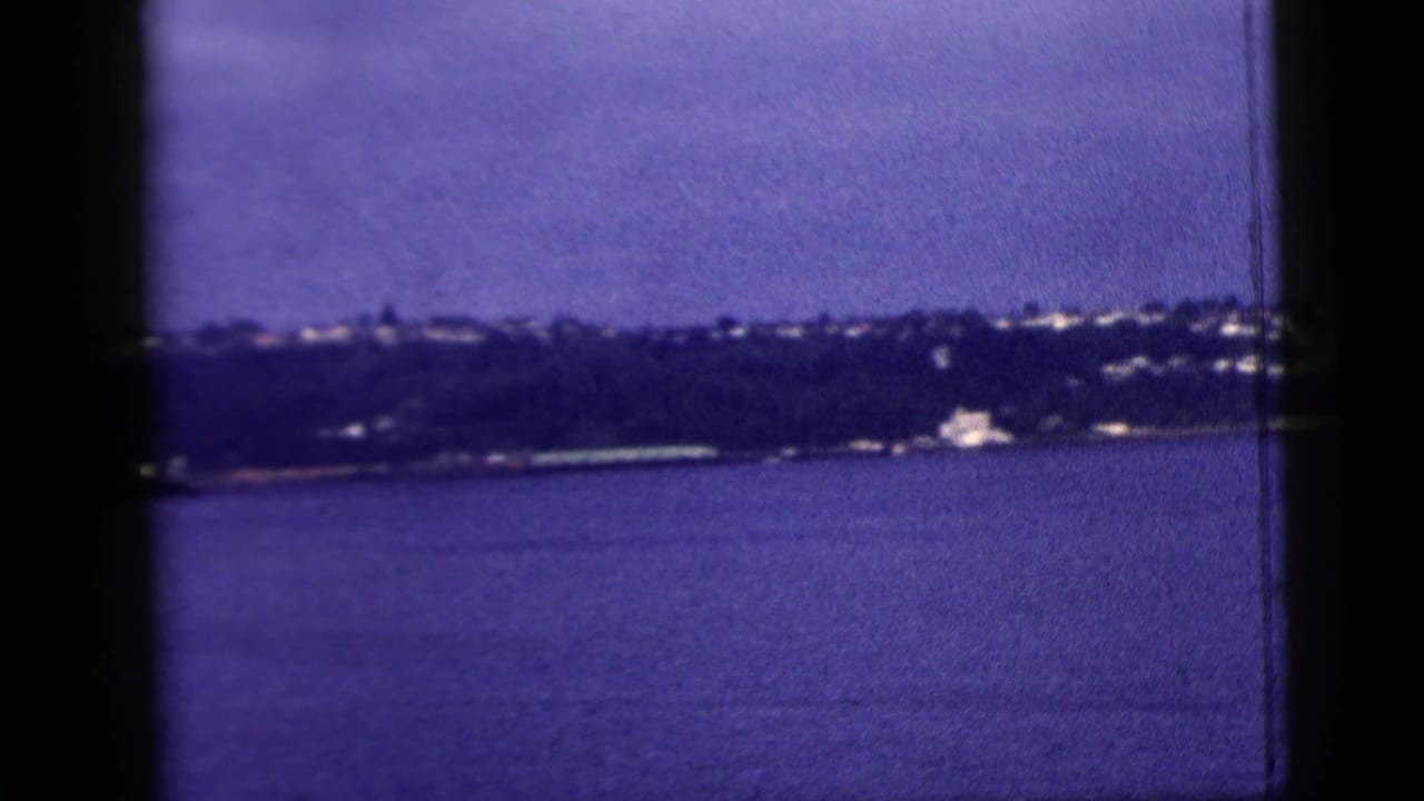Wide water view with dark vertical film borders and a low distant shoreline.